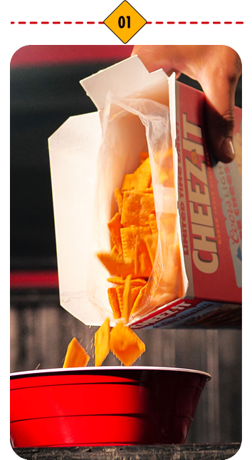 Cheez-It crackers being poured into a red bowl.